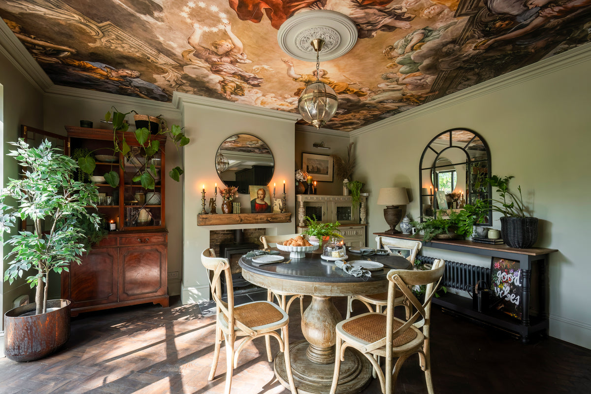 A dining room with dark wood furniture and warm metal accents by Delve Interiors
