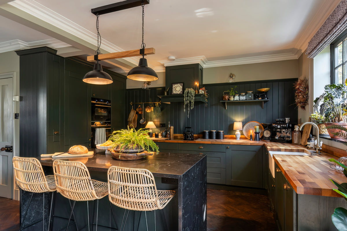 A kitchen with rich wood tones and warm metal hardware by Delve Interiors